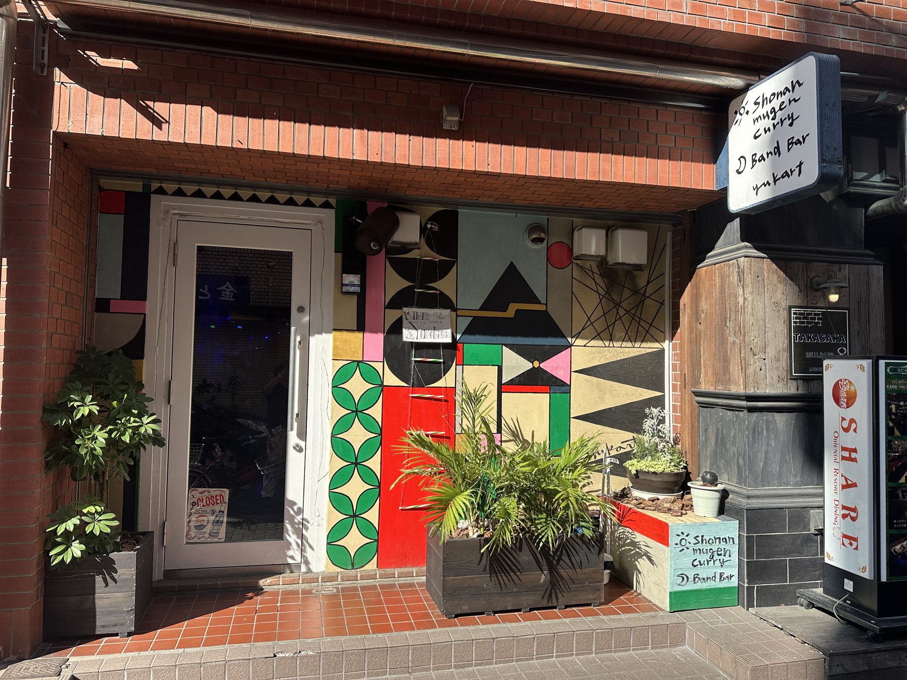 レンガの建物とカラフルな壁が目印の店舗入口